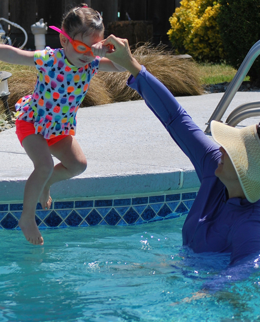 little girl jumping in pool